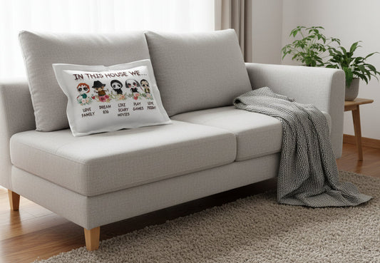 Gray sofa with a decorative pillow and blanket in a living room setting