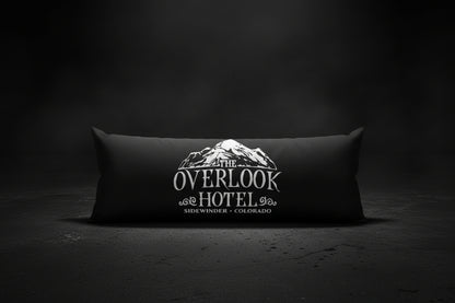 A long rectangular black pillow featuring a white graphic print of a mountain and the text 'THE OVERLOOK HOTEL' and 'SIDWINGER - COLORADO'.
