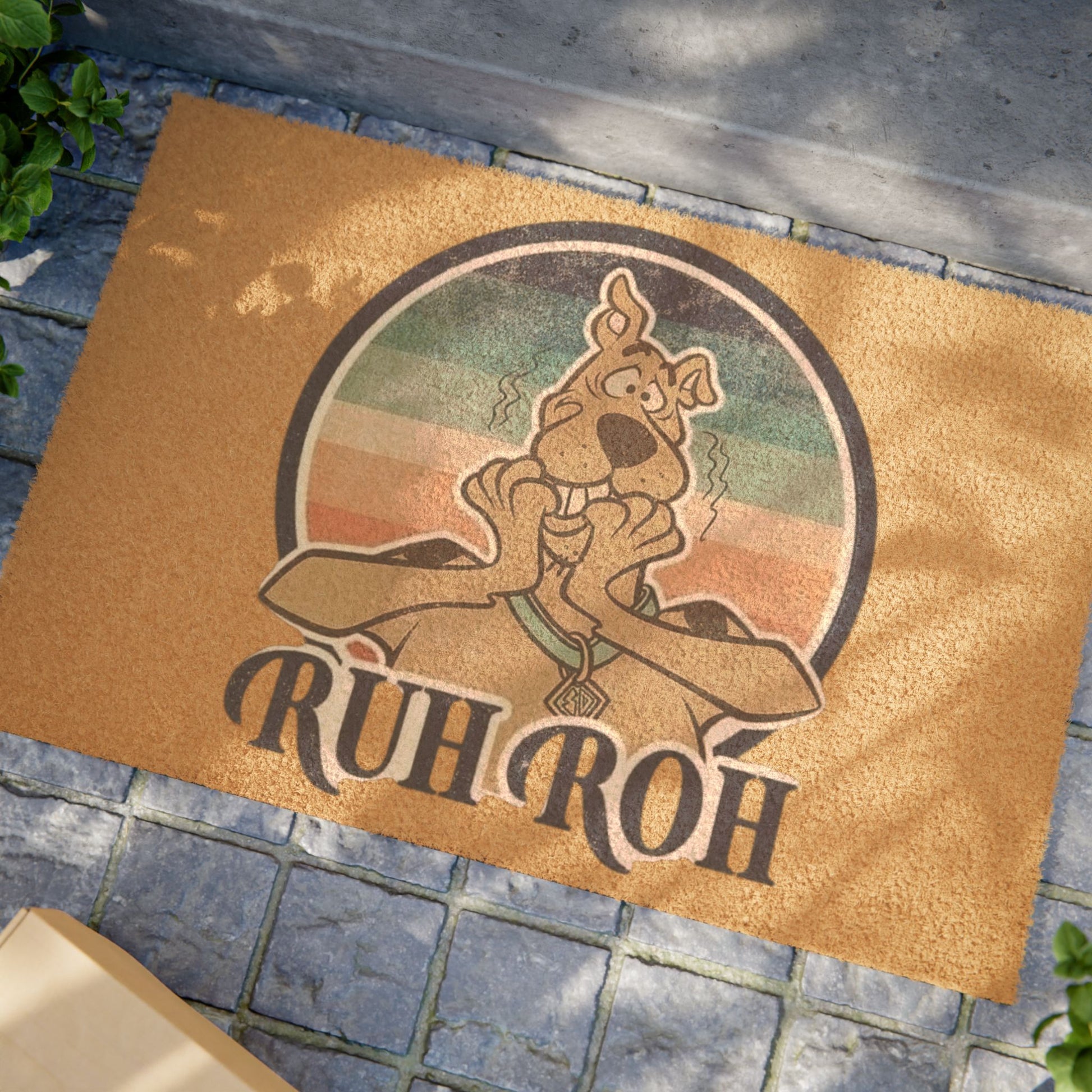Doormat with cartoon character and 'Rüh Roh' text on a stone floor.