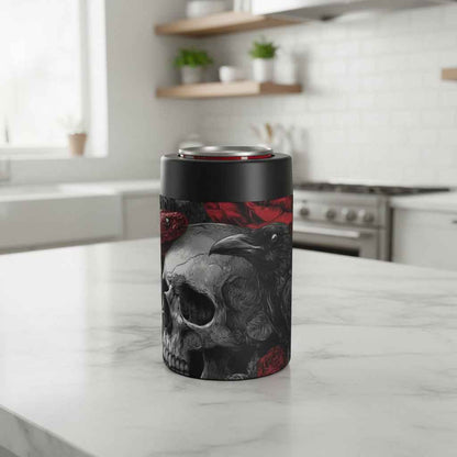 A slim can cooler with a black top and base, featuring a gothic graphic print of a skull, raven, red roses, and a snake on a white background.